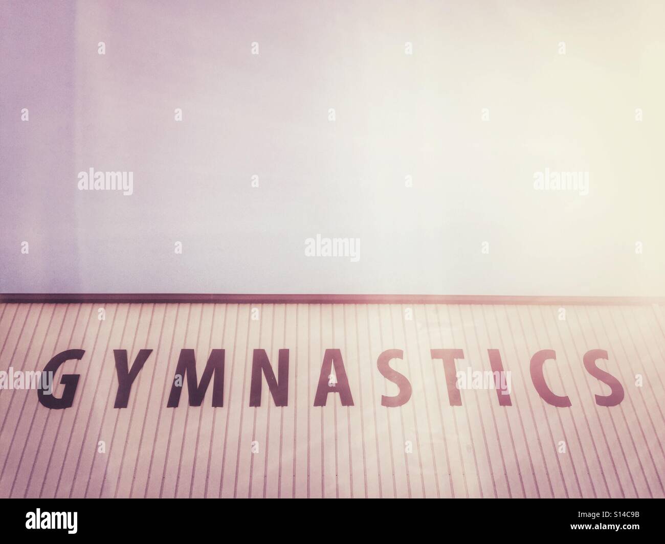 Large letters on the side of a building spell gymnastics. - Smartphone Captured Stock Image Large letters on the side of a building spell gymnastics. - Smartphone Captured Stock Image