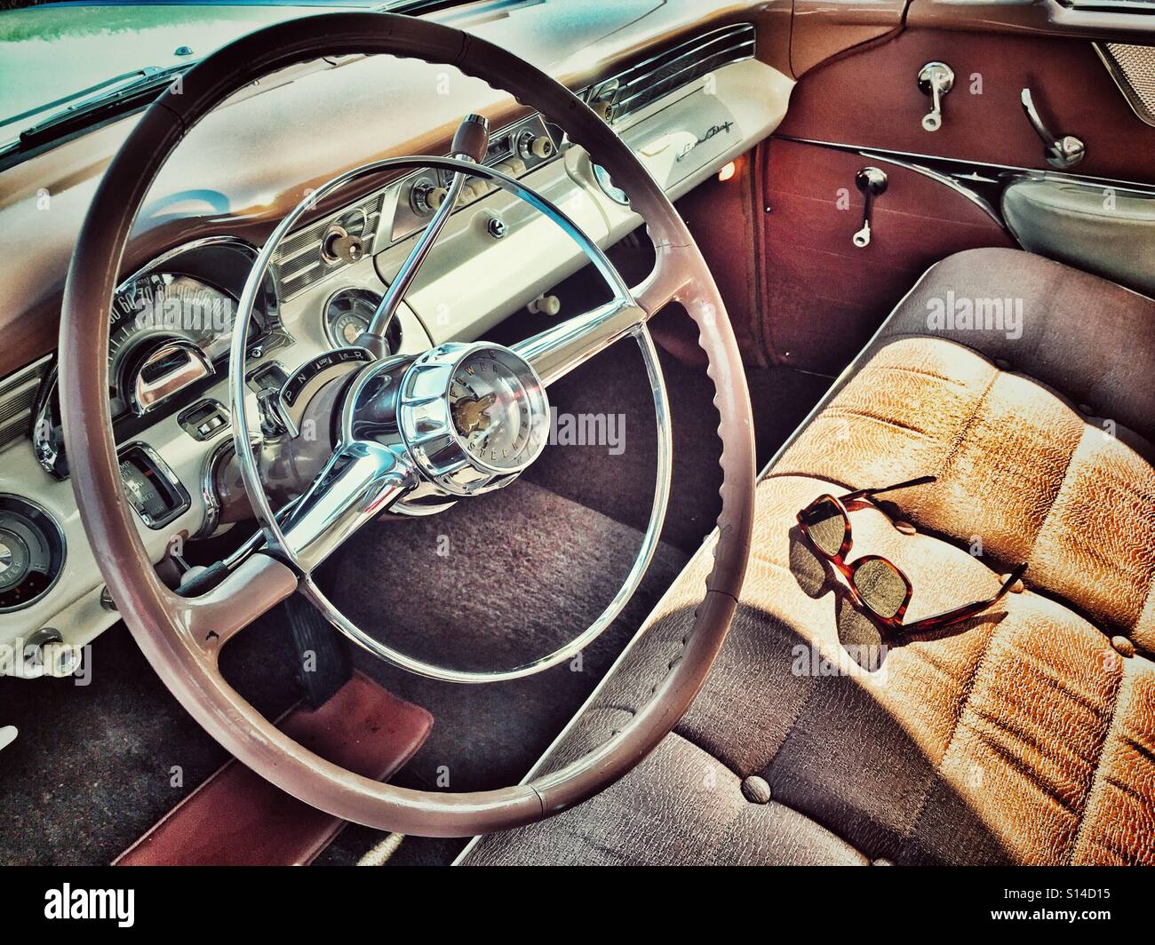 Sun shining through sunglasses casting a shadow on a classic American car bench seat - Smartphone Captured Stock Image