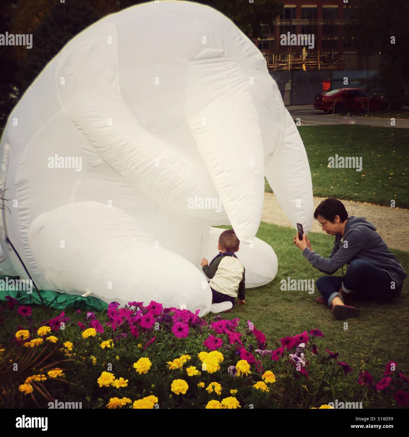 A woman photographs her child exploring a display at BeakerHead festival in Calgary, Canada. - Smartphone Captured Stock Image
