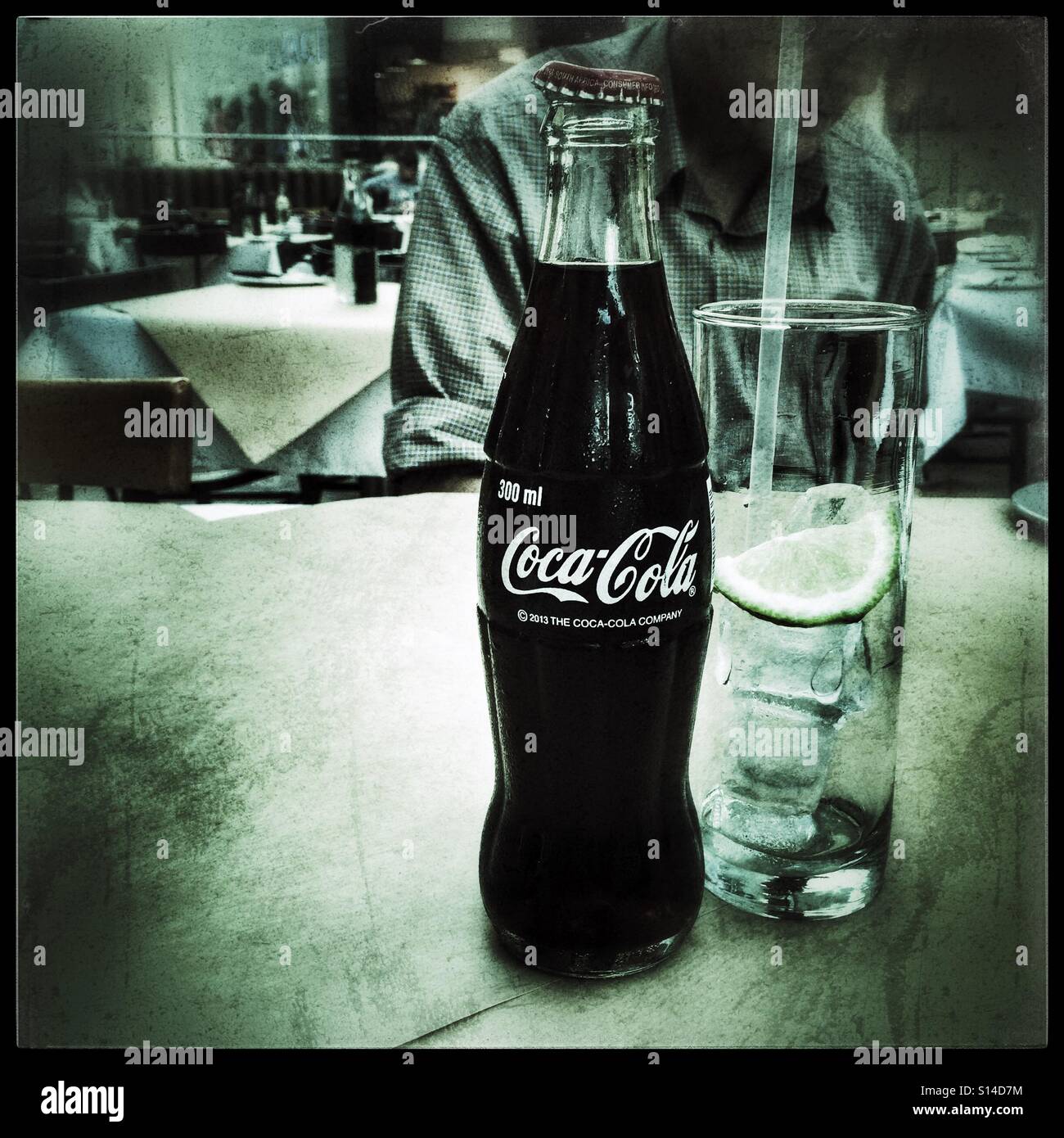 Bottle of coca-cola on table in restaurant. - Smartphone Captured Stock Image