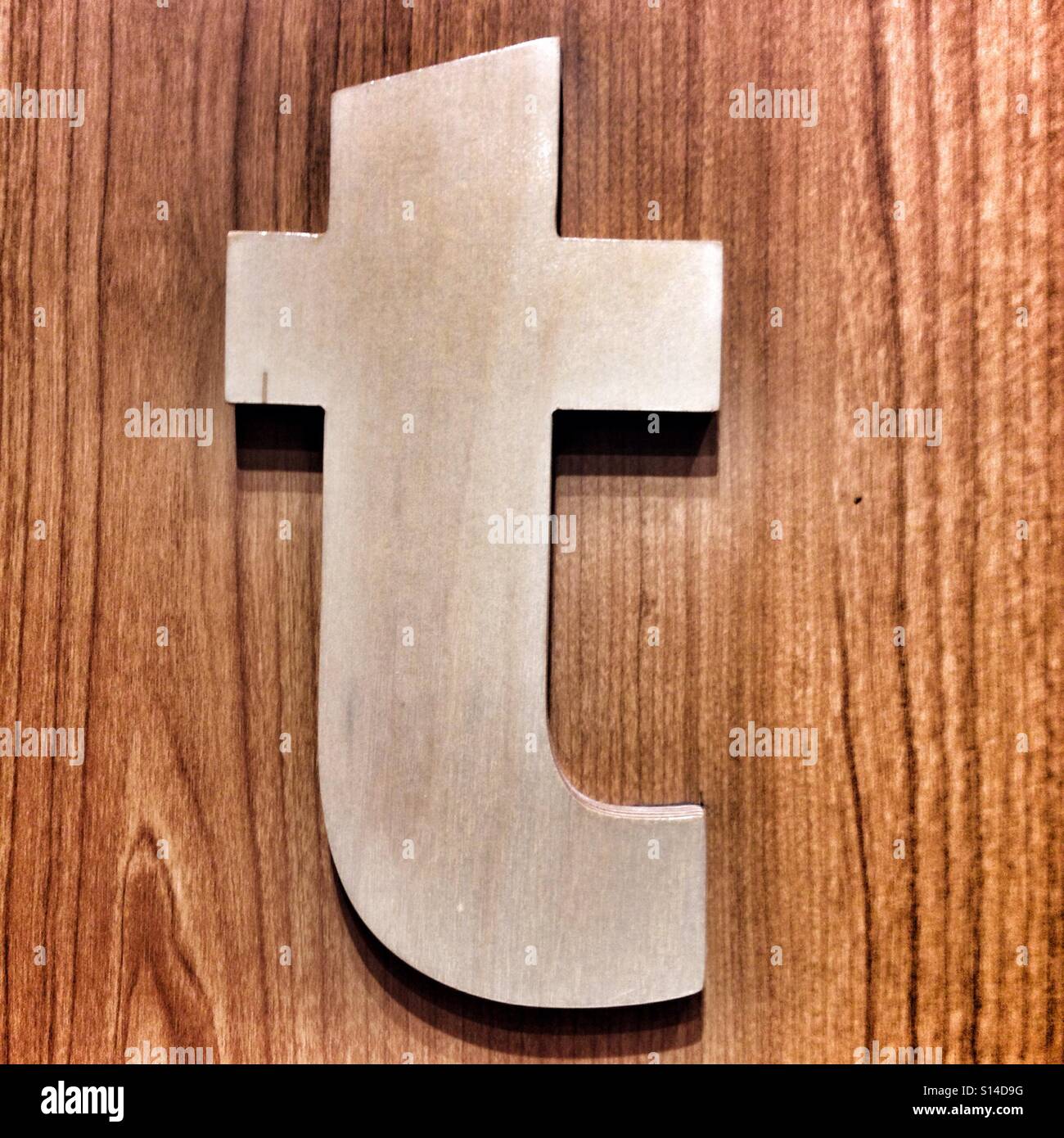 Lowercase White Letter T Hangs On Wooden Wall Background Stock Photo
