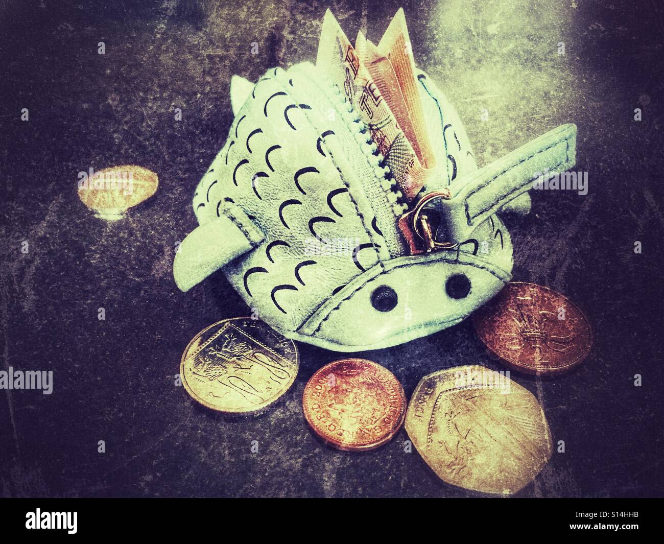 Blue fish purse, unzipped, with £10 note sticking out and loose coins on the side. - Smartphone Captured Stock Image