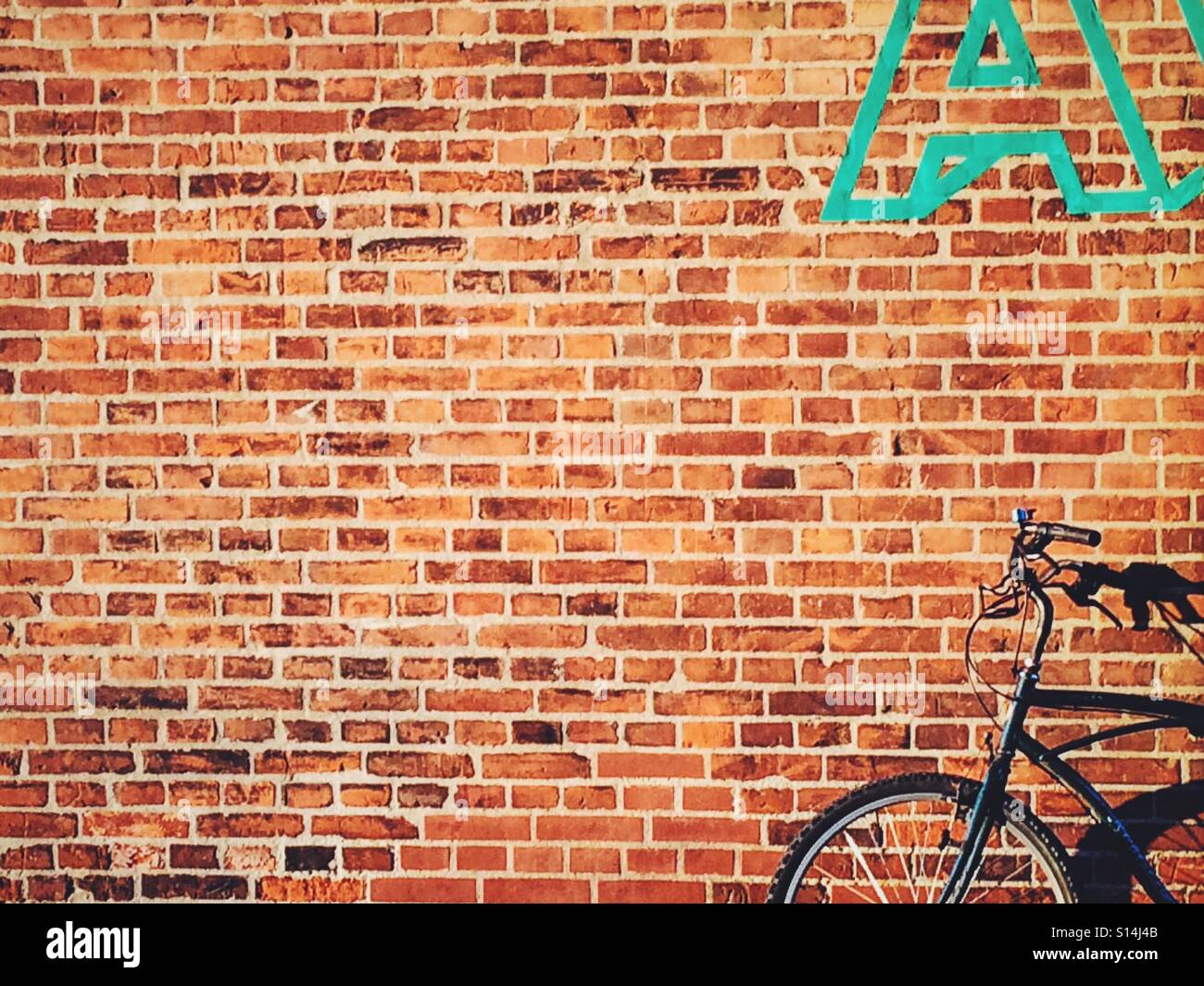 Bicycle against a brick wall in the streets of Copenhagen, Denmark - Smartphone Captured Stock Image