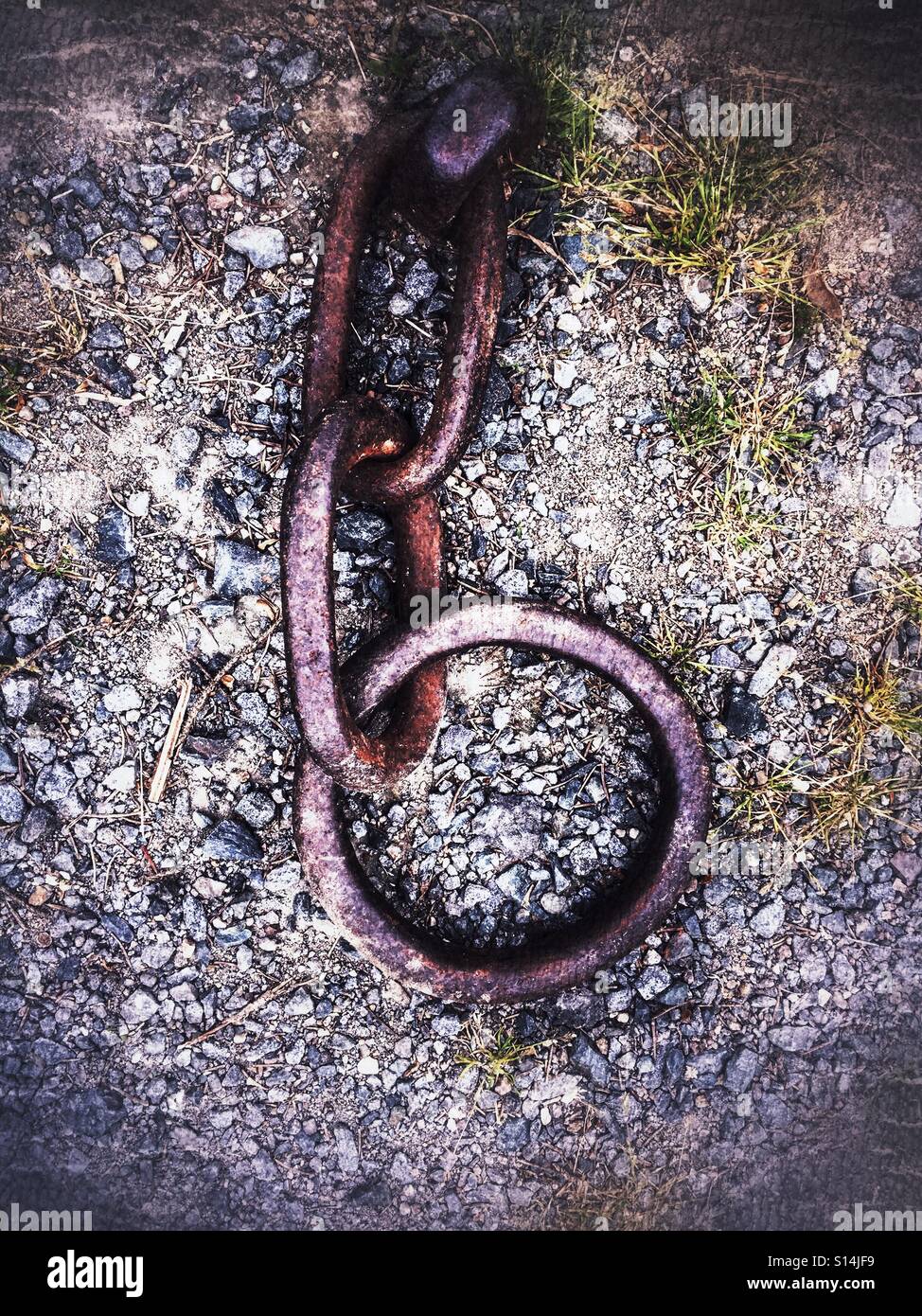 Old rusted chain hooked to ground - Smartphone Captured Stock Image