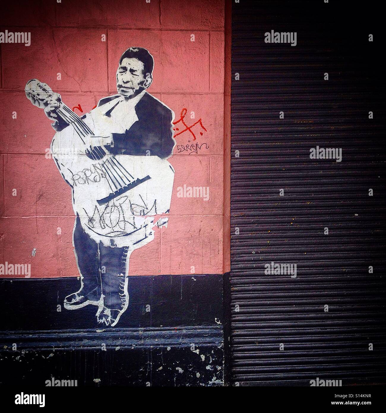 A sticker of a mariachi playing a bass guitar decorates a street of Mexico City, Mexico - Smartphone Captured Stock Image