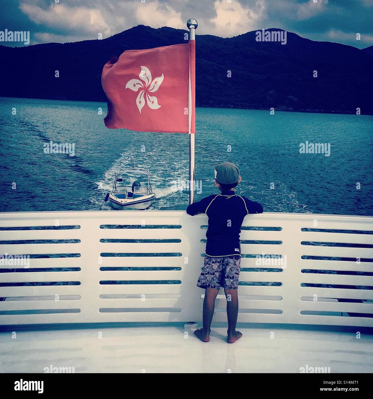 Kid on a boat with Hong Kong flag Stock Photo