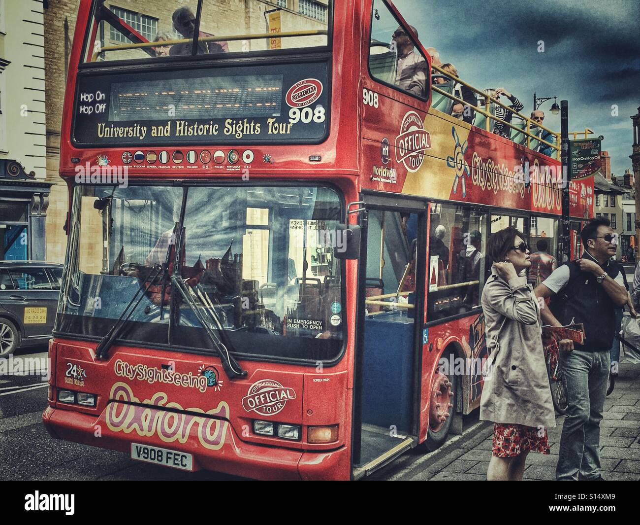 Tourists leaving Oxford City Sightseeing tour bus at the bus stop in Broad Street, Oxford, England - Smartphone Captured Stock Image