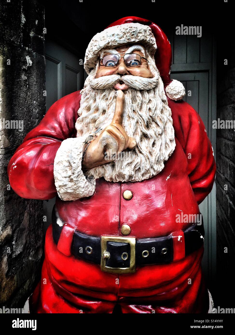 A high contrast image of a model of Father Christmas. He is gesturing to everyone to either be quiet or keep the noise down. Photo Credit - © COLIN HOSKINS. Stock Photo
