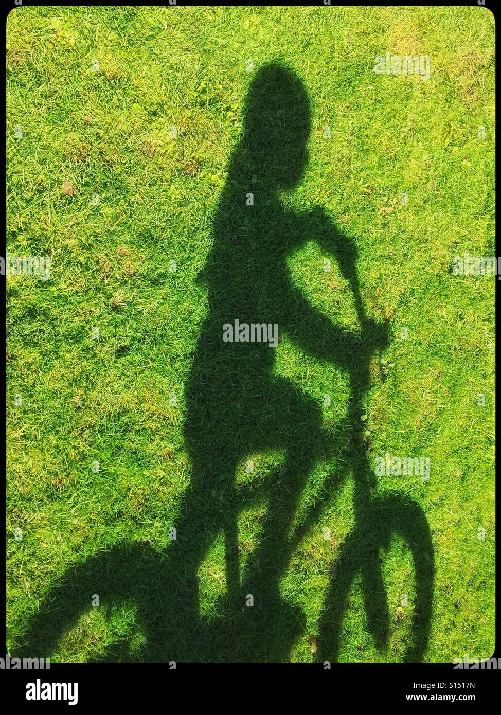 The shadow of a four year old girl on green grass, just as she is going to ride off on her bicycle. An image to illustrate childhood, play, fun & anonymity. Photo Credit - © COLIN HOSKINS. - Smartphone Captured Stock Image The shadow of a four year old girl on green grass, just as she is going to ride off on her bicycle. An image to illustrate childhood, play, fun & anonymity. Photo Credit - © COLIN HOSKINS. - Smartphone Captured Stock Image