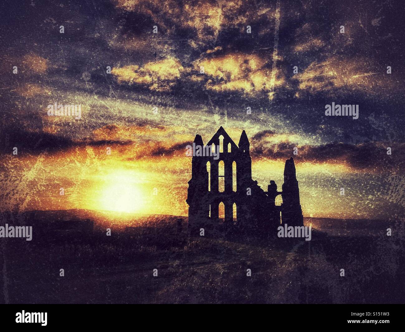 Setting sun and silhouette of Whitby Abbey - Smartphone Captured Stock Image