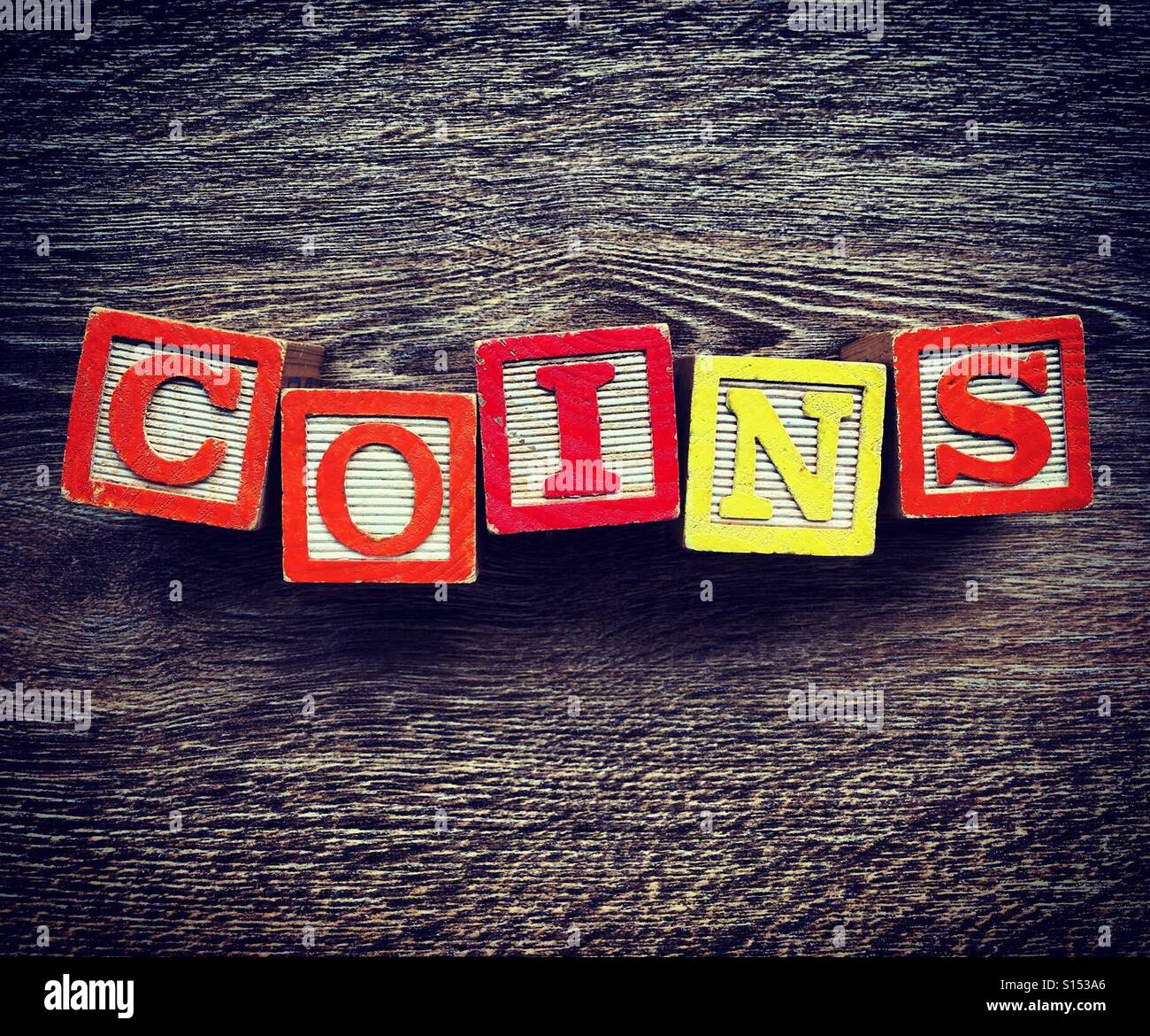 COINS word written with alphabet wood block letter toys - Smartphone Captured Stock Image