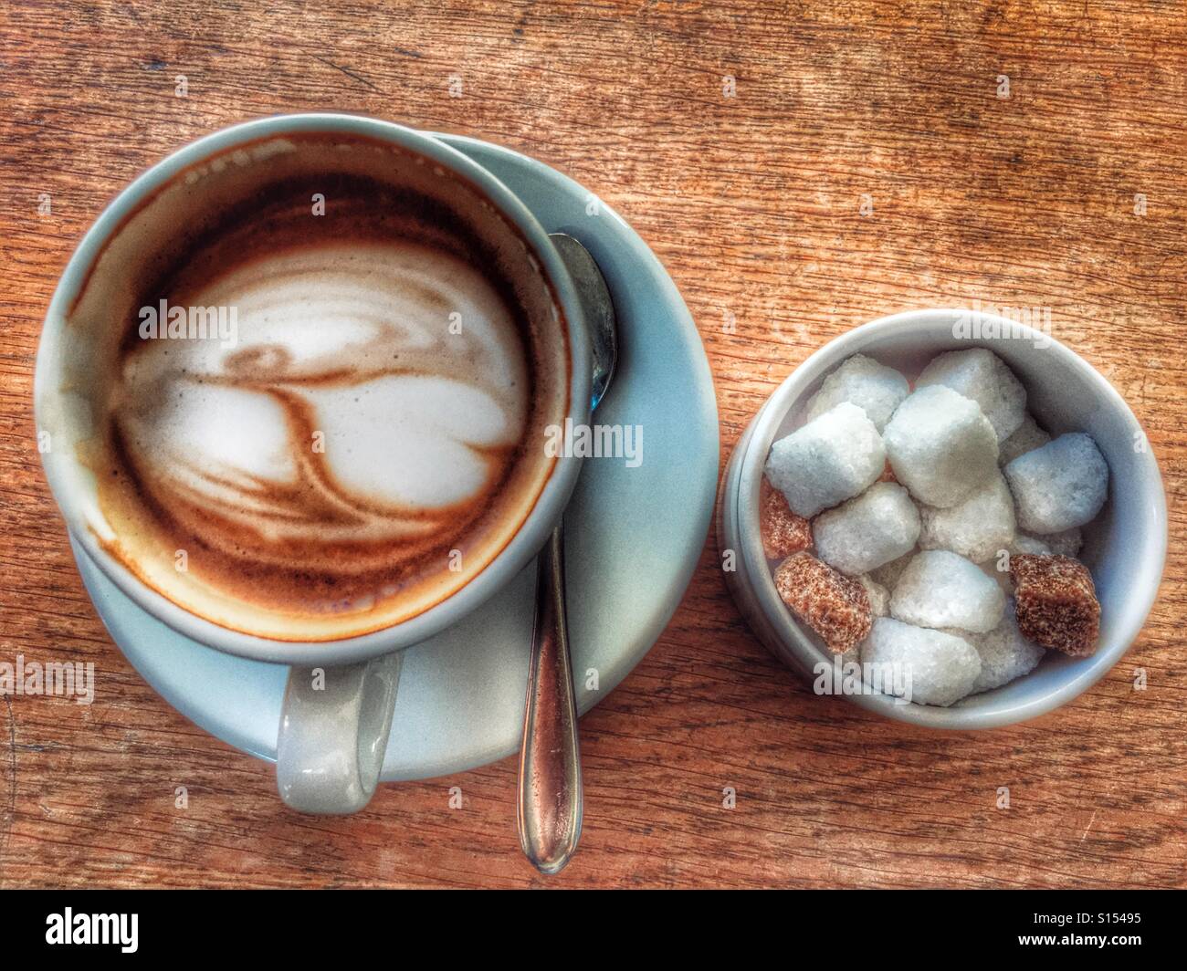 Partly drunk cup of cappuccino coffee, next to a bowl of sugar - Smartphone Captured Stock Image