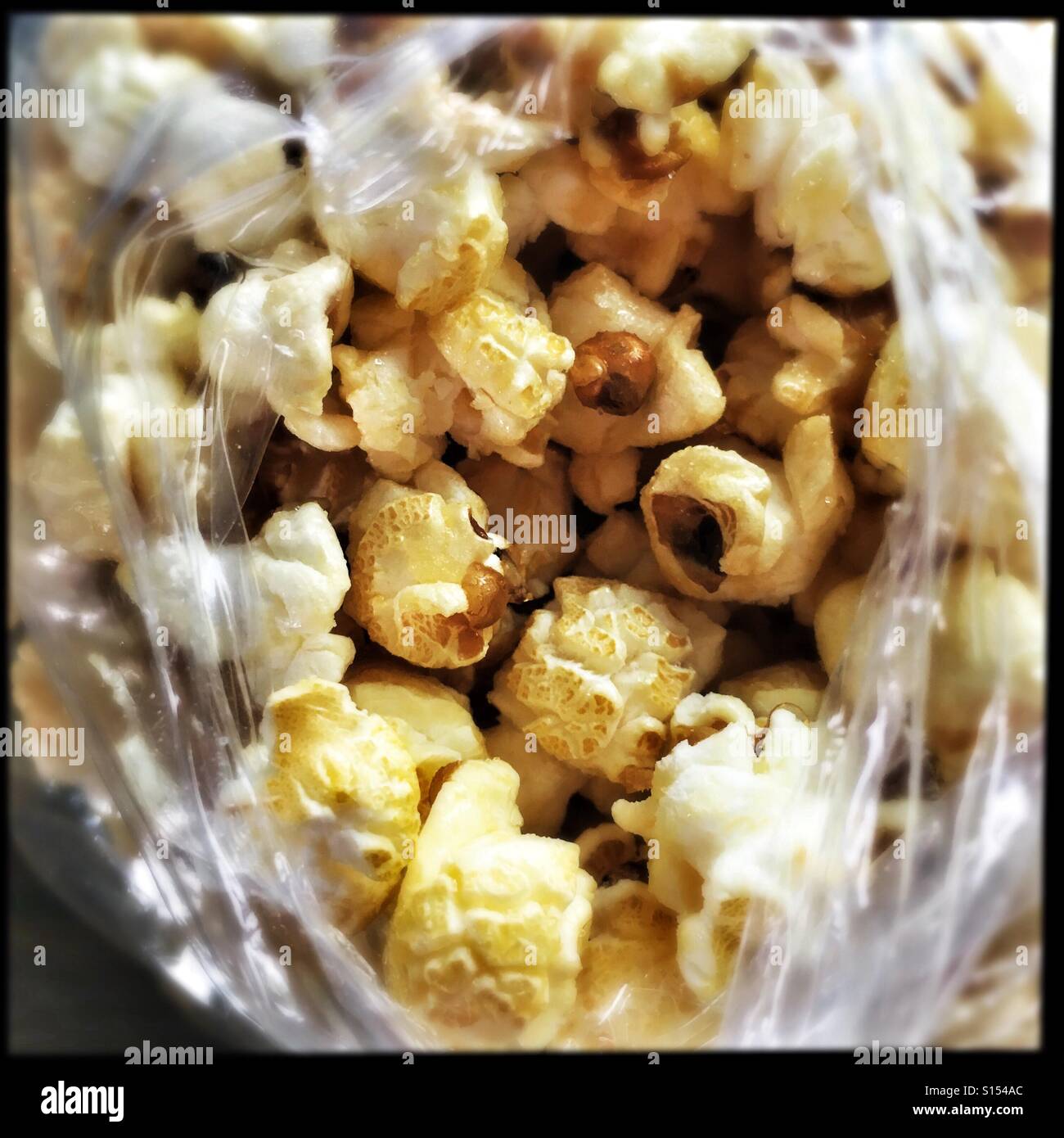 Kettle popcorn seen through a torn plastic bag. - Smartphone Captured Stock Image