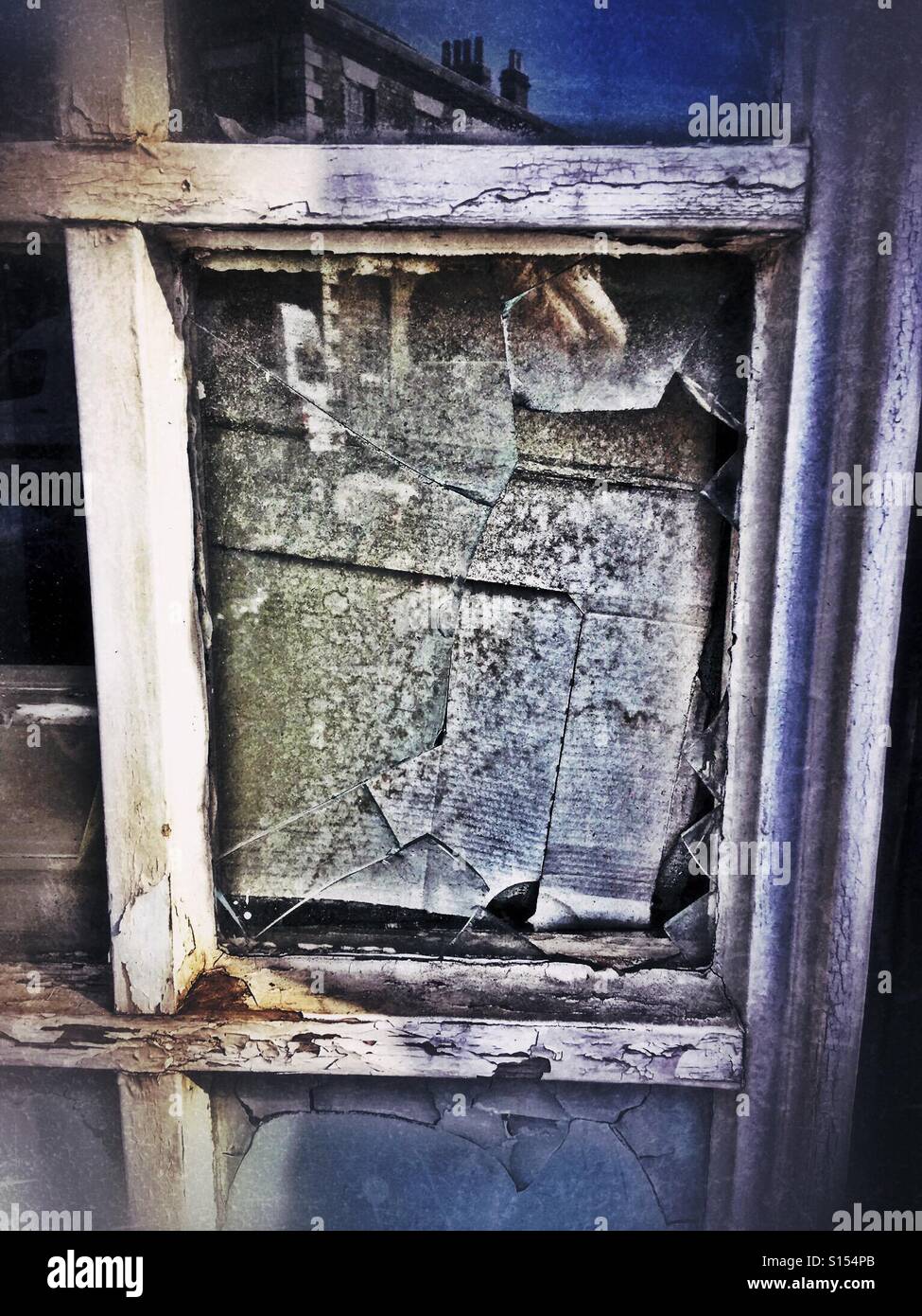 Broken window in dirty, old frame stuffed with cardboard - Smartphone Captured Stock Image