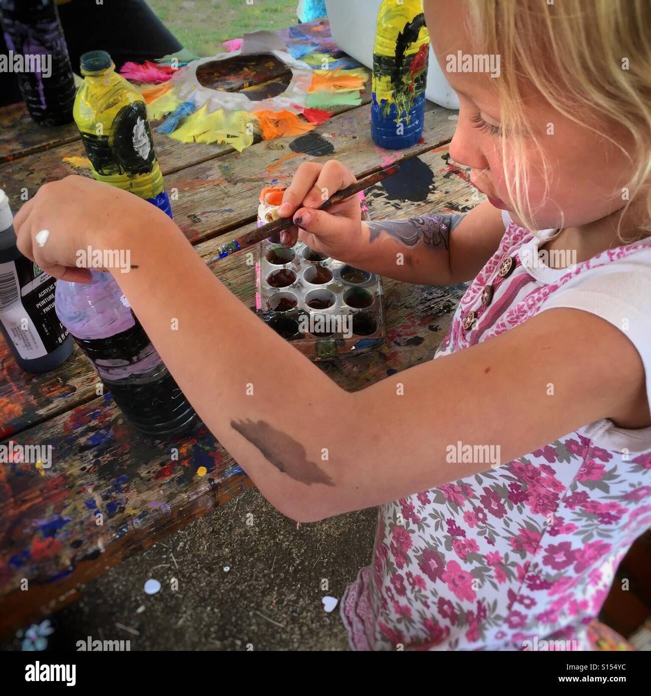 A girl paints a plastic bottle at a craft program. - Smartphone Captured Stock Image