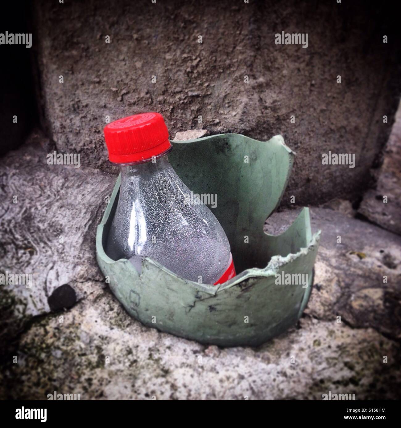 A bottle of a soft drinks inside a drain tube in Mexico City, Mexico - Smartphone Captured Stock Image