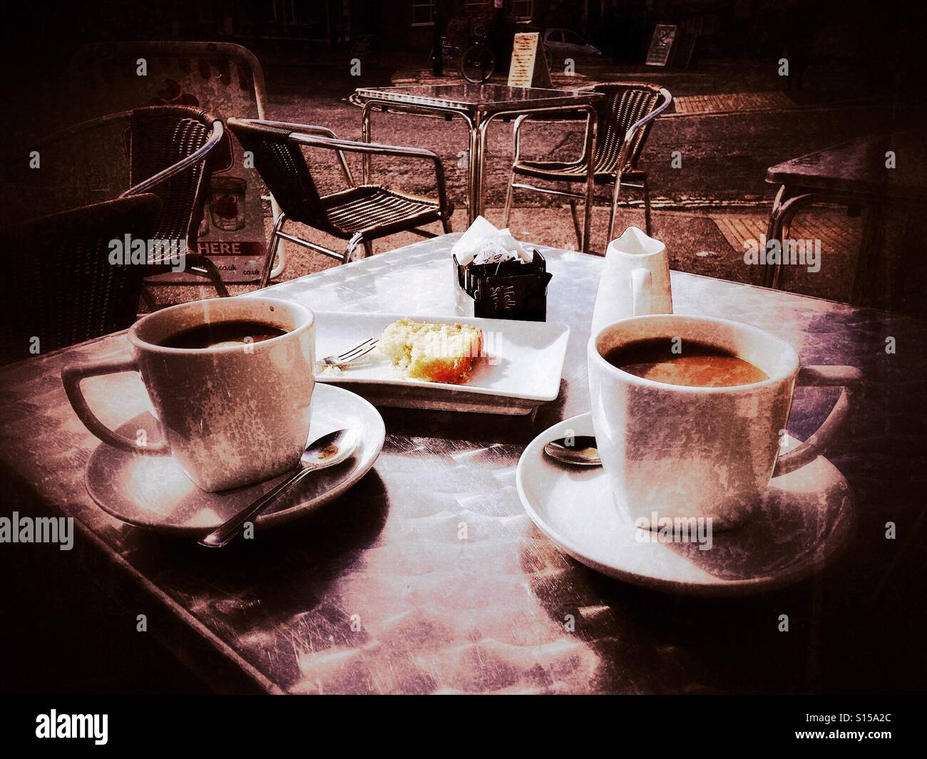 Cafe culture - two coffees in white cups and saucers on an outdoor table. Stock Photo