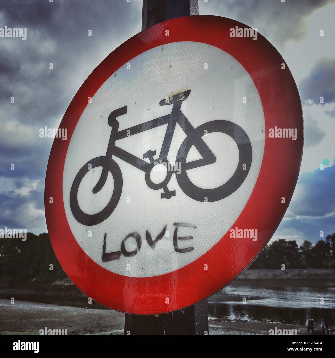 Love Graffitti on an public street sign allowing cycling on a public path and warning pedestrians - Smartphone Captured Stock Image