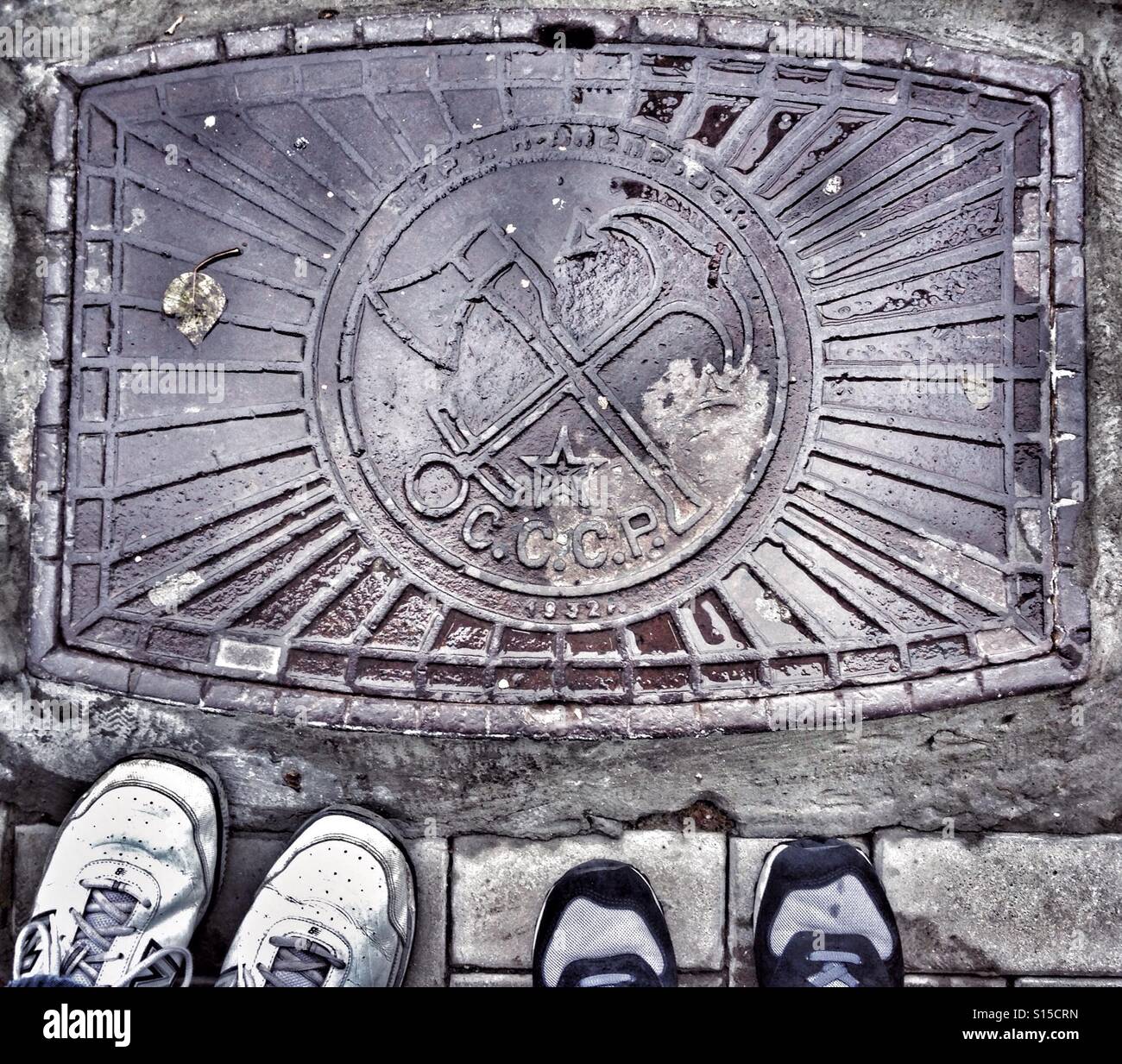 Manhole with Russian sign CCCP and symbols. English translation - USSR - Smartphone Captured Stock Image