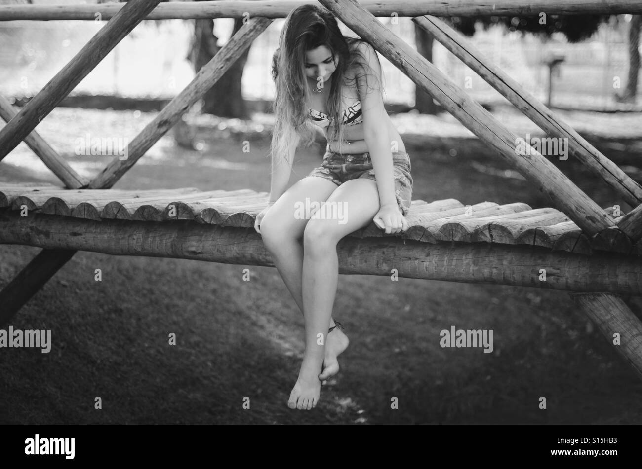 Girl sitting on the bridge Stock Photo
