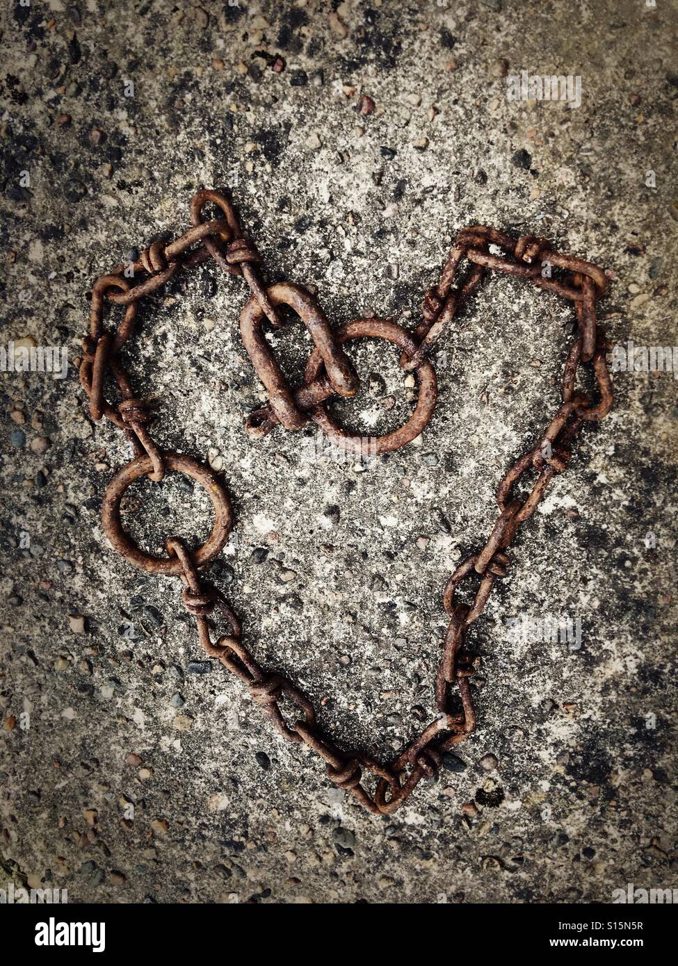 Old chain at the harbour in Buckie, Scotland, laid out in the shape of a heart. Stock Photo