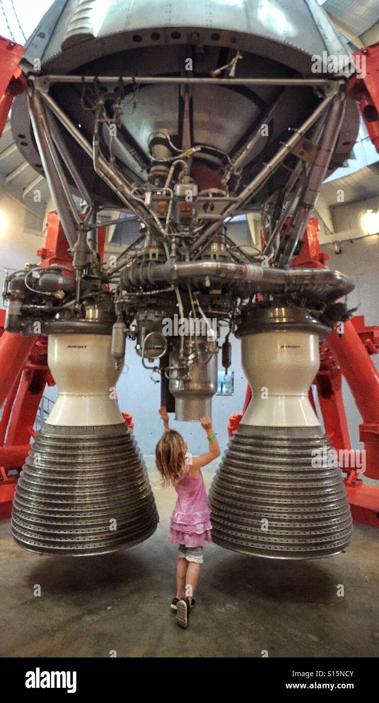 A girl inspects the underside of a rocket. - Smartphone Captured Stock Image