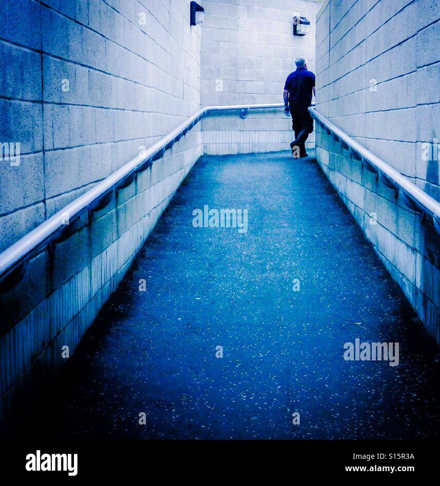 Man waling uphill in a blue alley - Smartphone Captured Stock Image