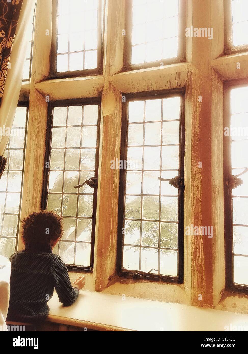 A boy looks through a window. - Smartphone Captured Stock Image