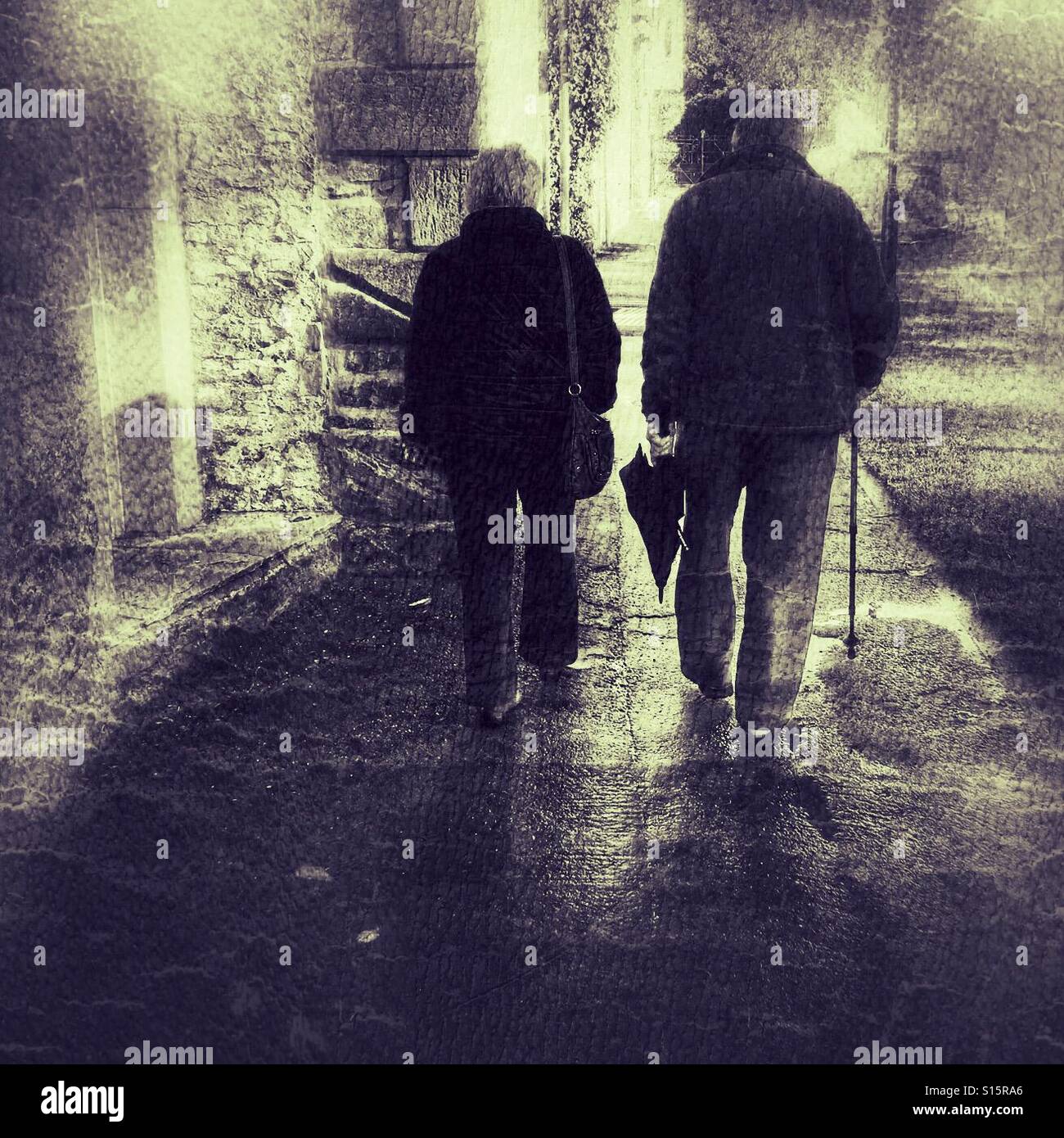 Couple walking after a rain shower. Man carrying closed umbrella and walking stick - Smartphone Captured Stock Image