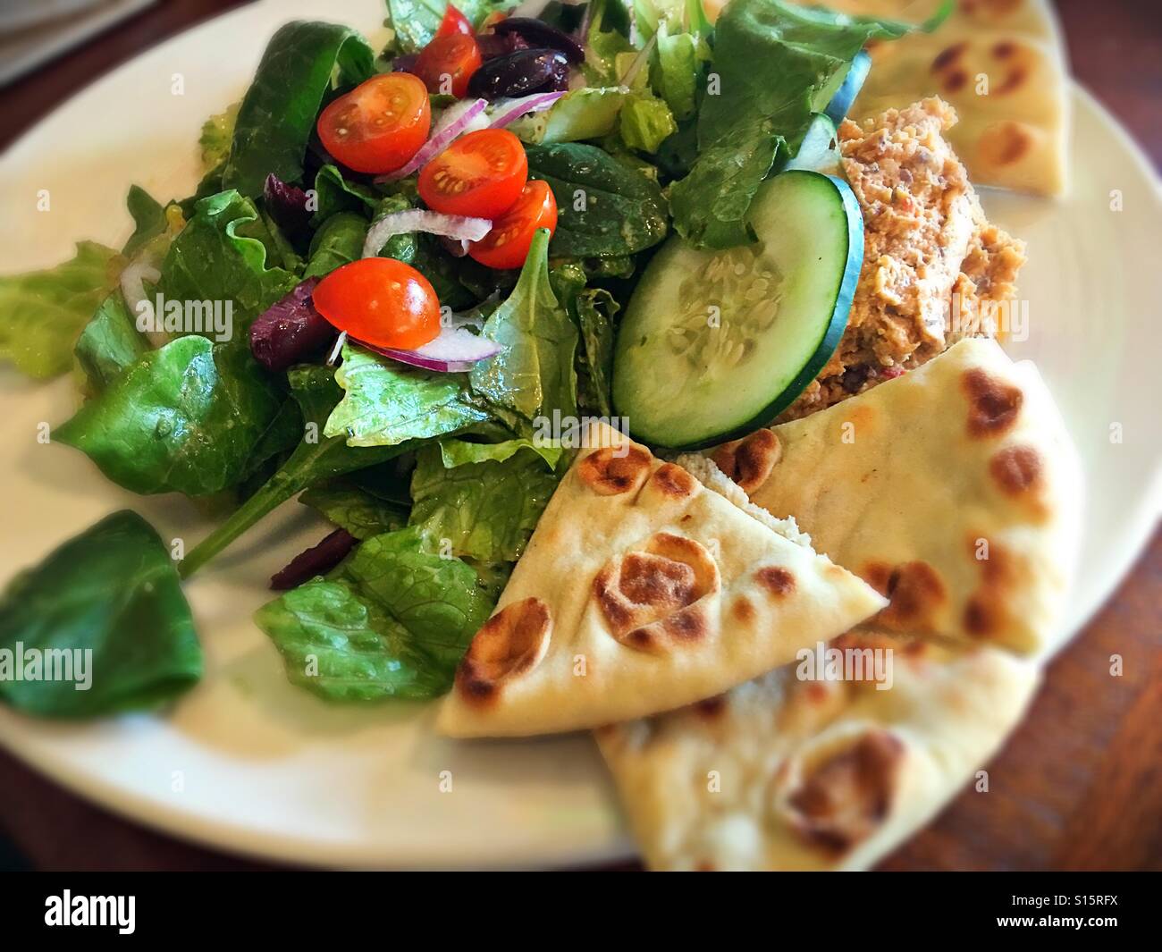 Plant based meal of salad, hummus and pita. Stock Photo
