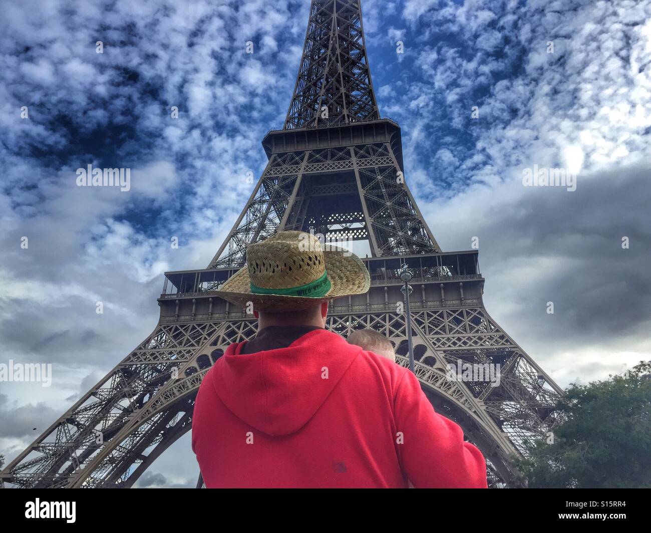 Man holding baby in the front of The Eiffel Tower Paris France Stock