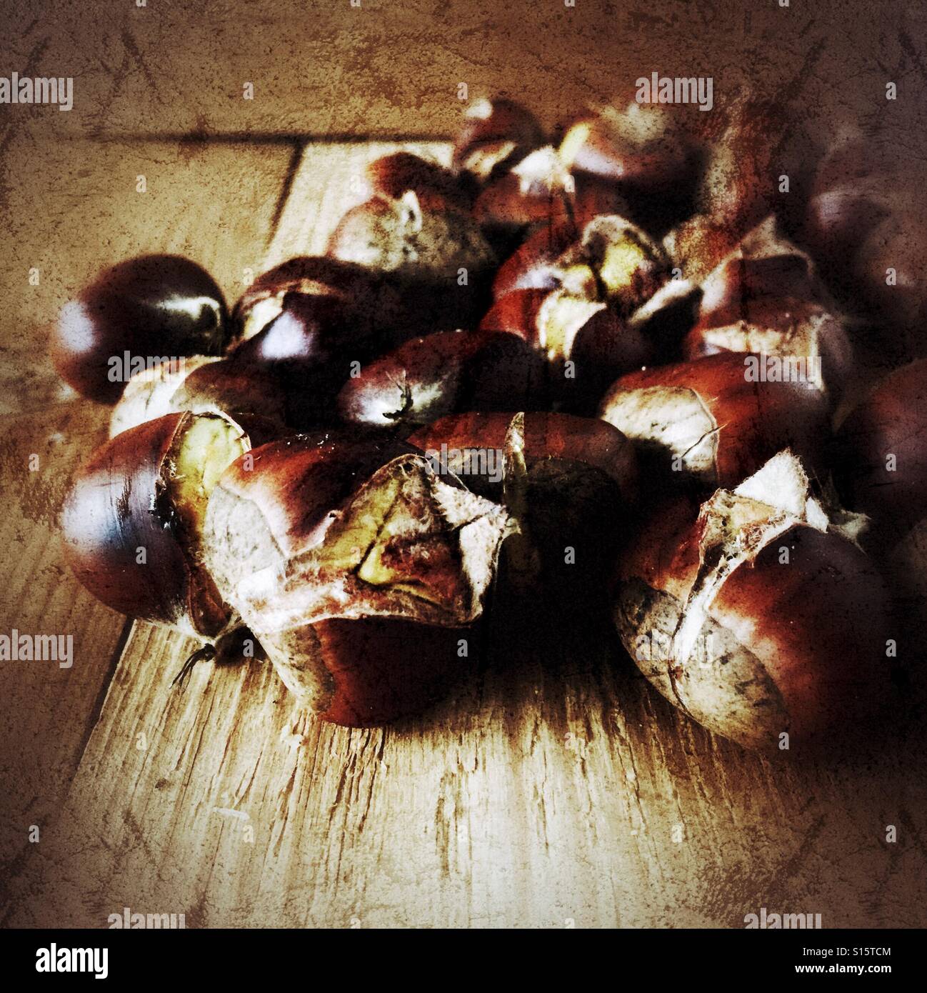 Roasted chestnuts on a wooden surface. Distressed edit. - Smartphone Captured Stock Image