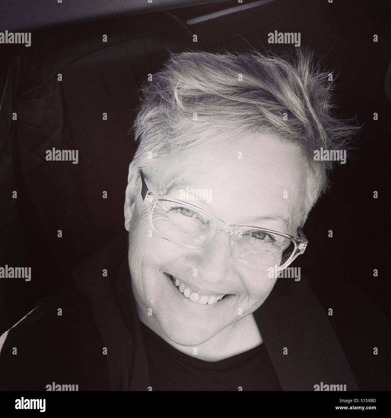 Middle aged smiling woman with funky haircut and trendy specs Stock Photo
