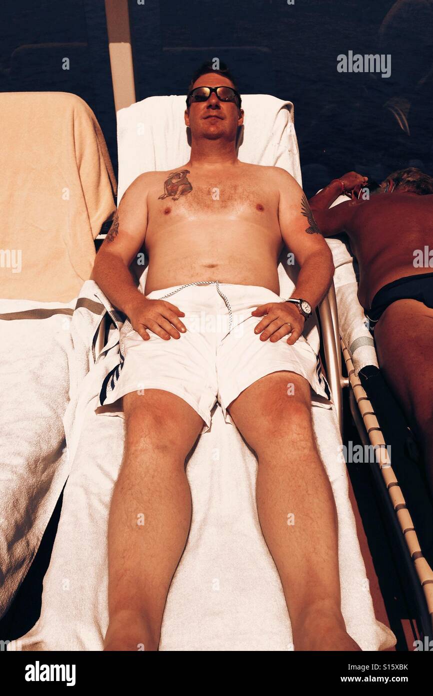 Man sunbathing on a cruise ship Stock Photo