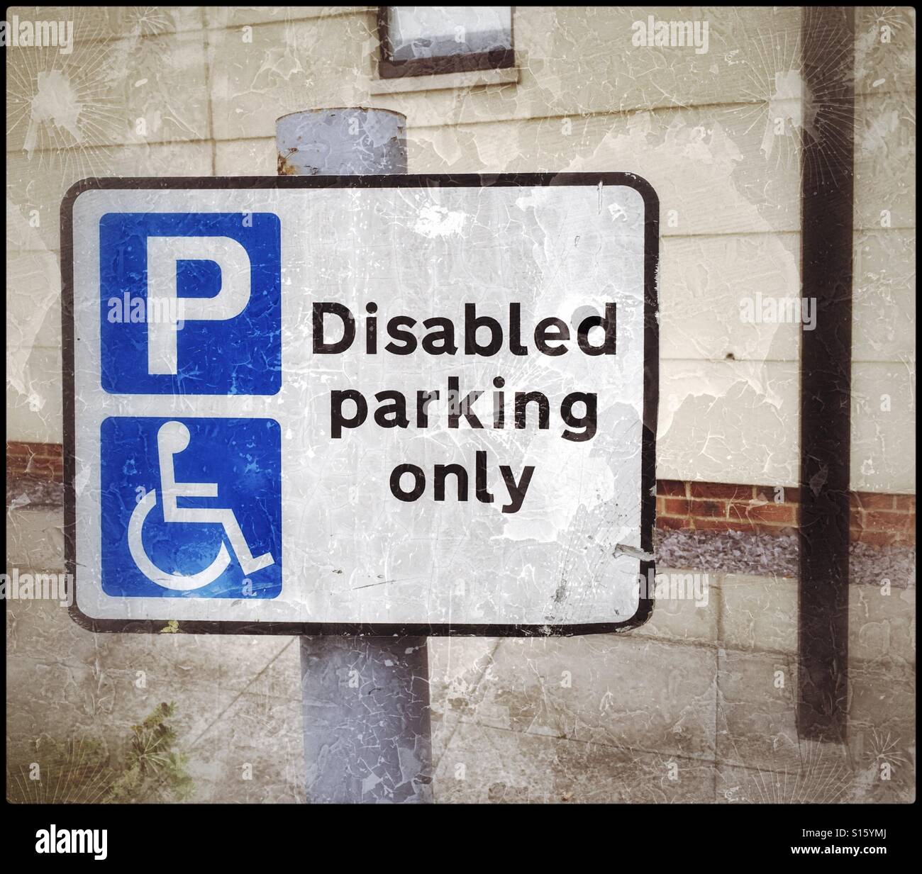 A grunge effect picture of a 'Disabled parking only' vehicle parking bay/area/space. The universal sign of the person in a wheelchair is used with a blue P sign. Photo Credit - © COLIN HOSKINS. - Smartphone Captured Stock Image