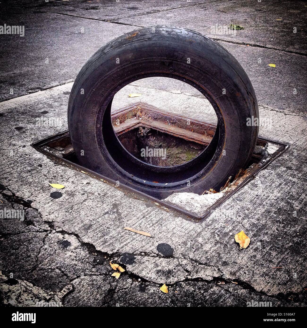 A tire covers a hole in Mexico City, Mexico Stock Photo