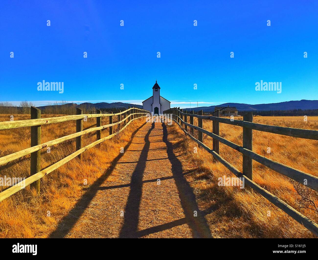Little historical country church with pathway and rail fence with heavy ...