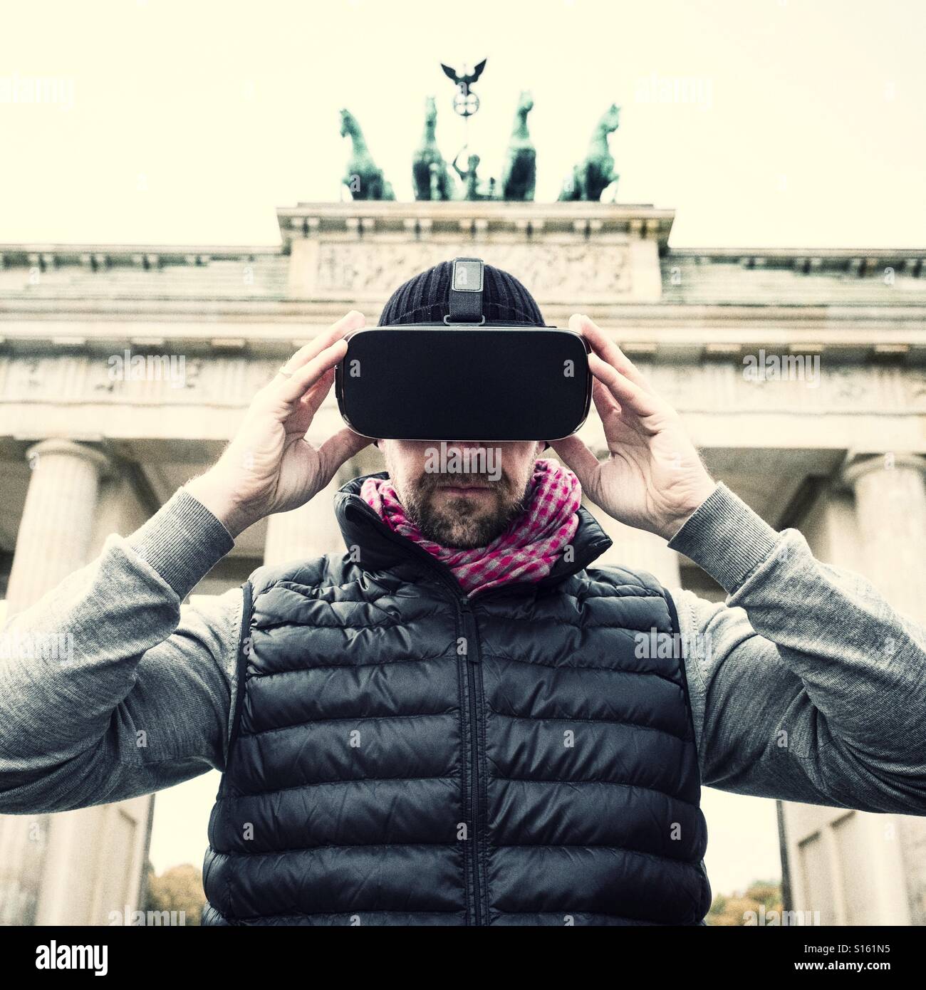 Man wearing VR virtual reality headset at Brandenburg gate in Berlin - Smartphone Captured Stock Image
