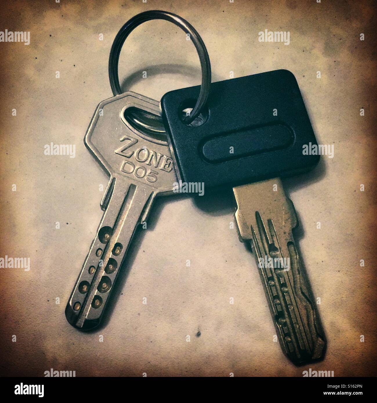 Two keys of house door in close up with a key ring safety home owner everyday object metal lock locking closing safety secure estate property - Smartphone Captured Stock Image