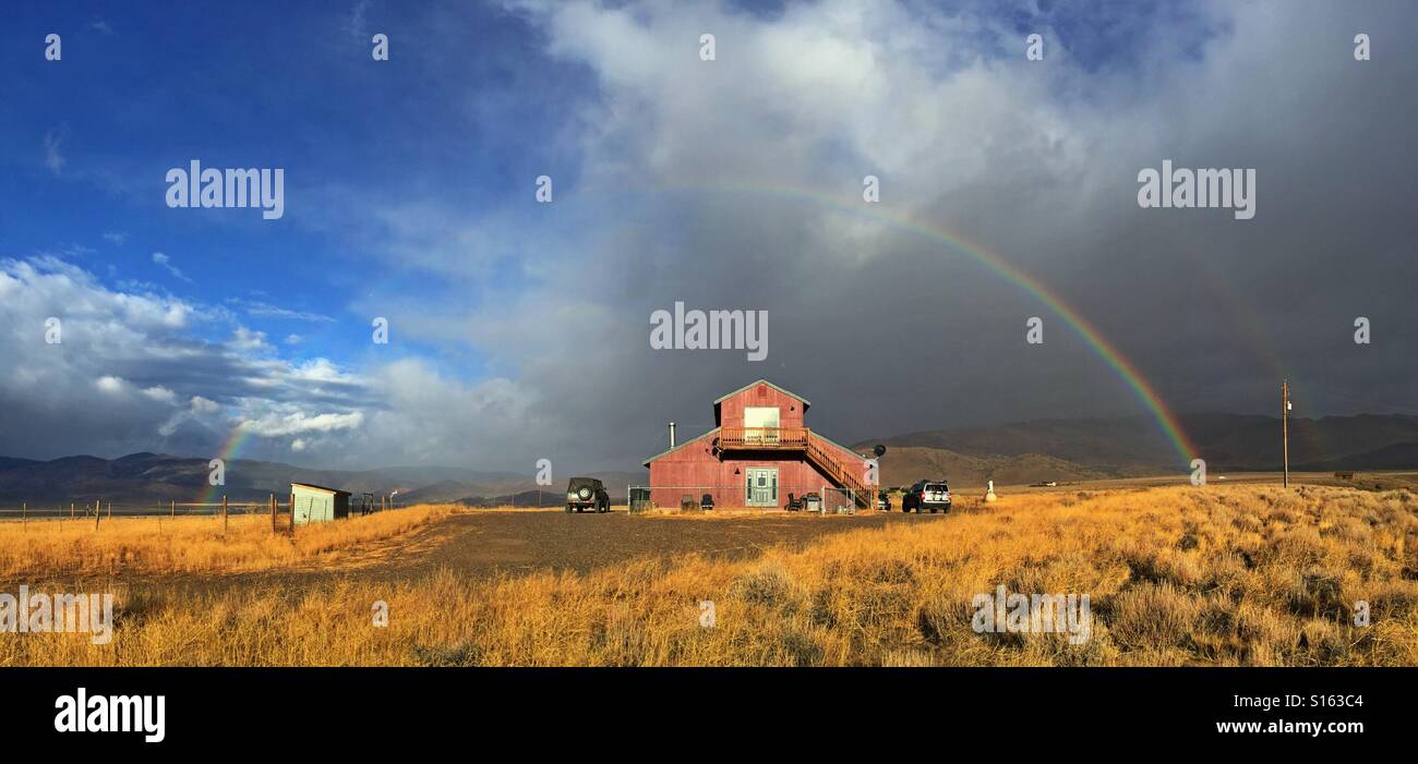 Barn home with rainbow in Nevada Stock Photo