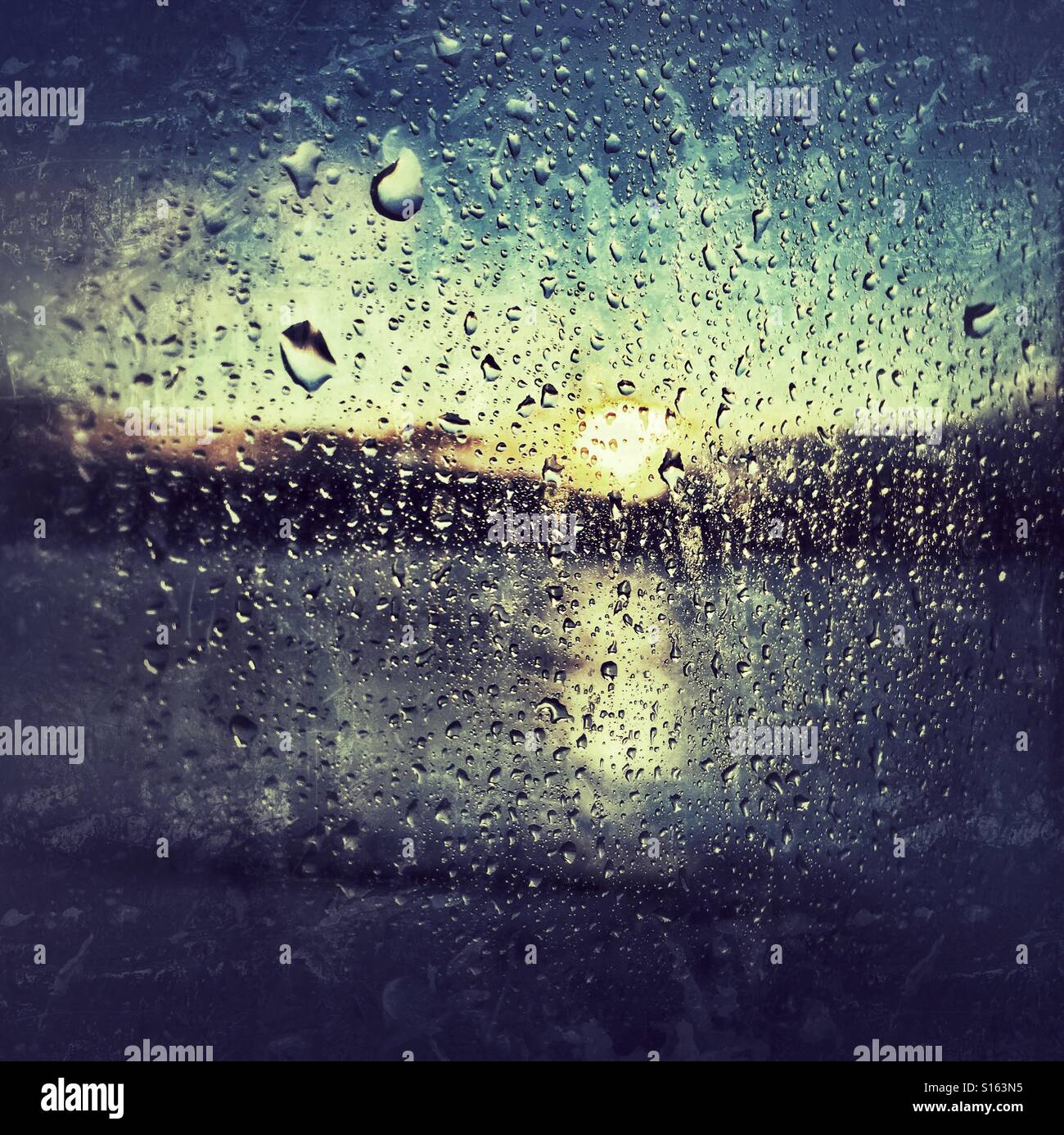 Sun coming up through a curtain of raindrops Stock Photo