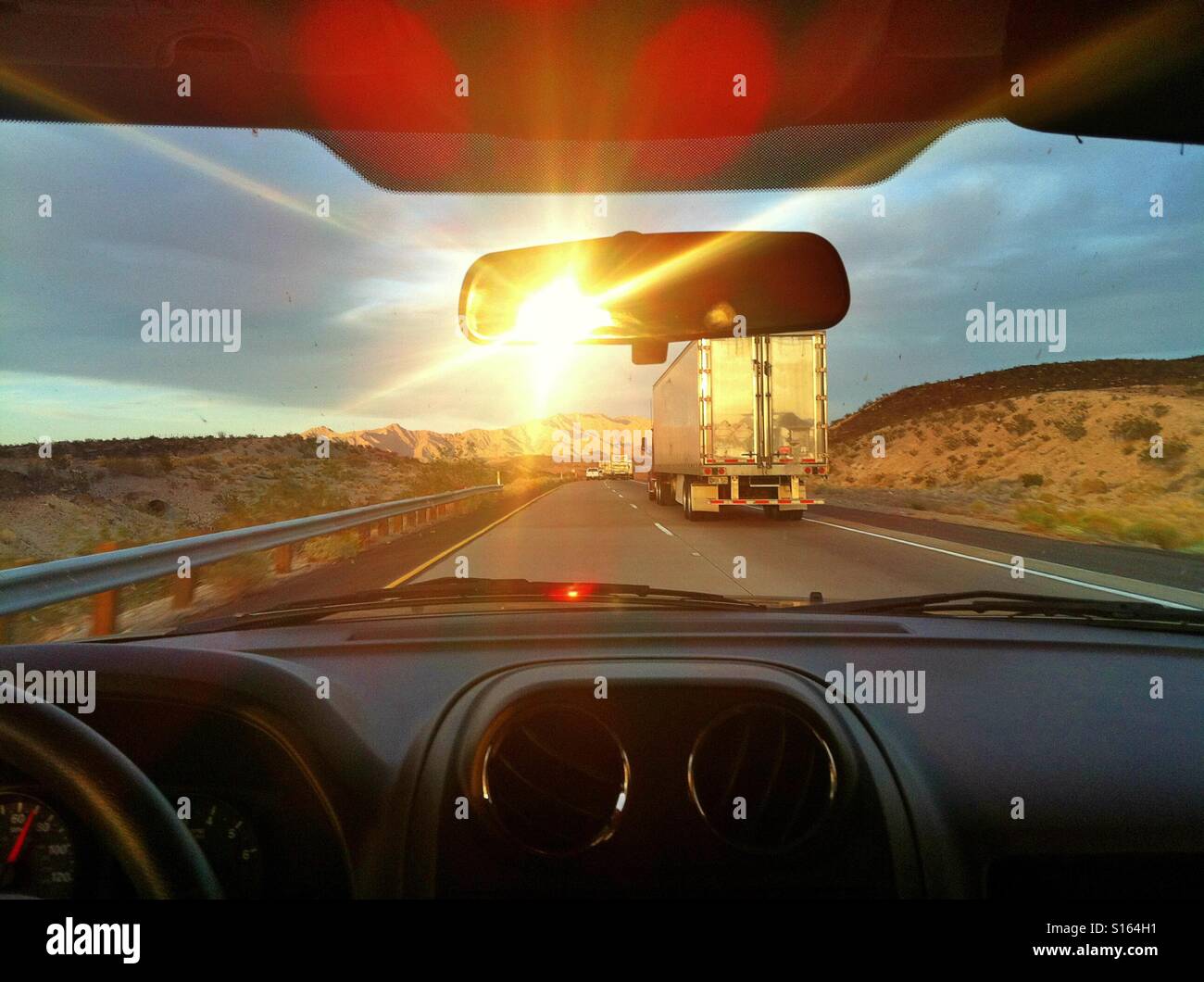 Traveling on highway with the sun setting Stock Photo