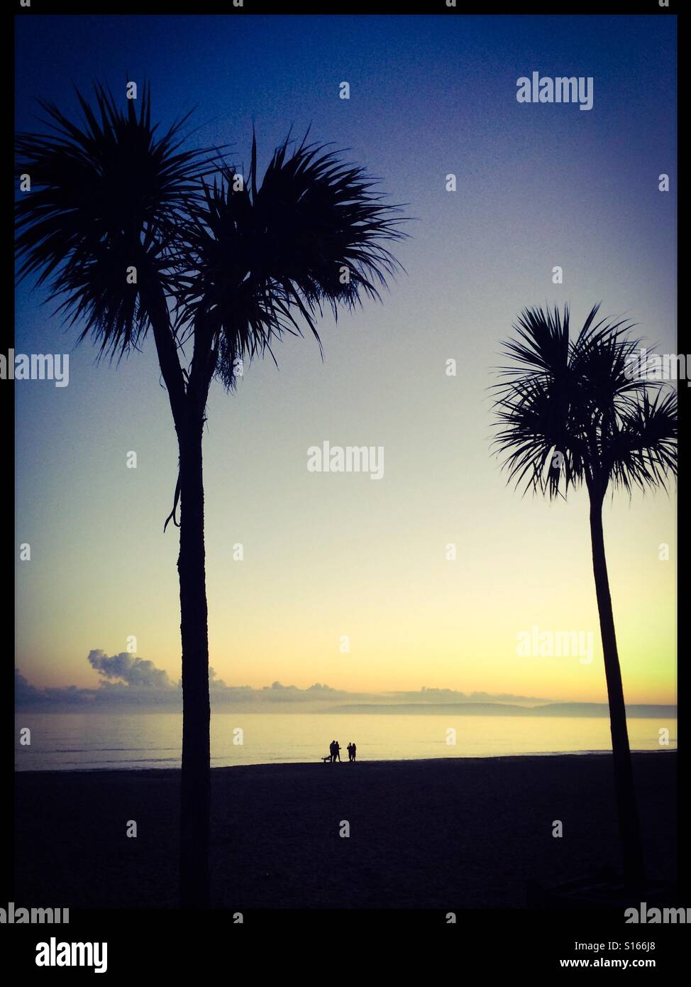 Walking on the beach at sunset Stock Photo