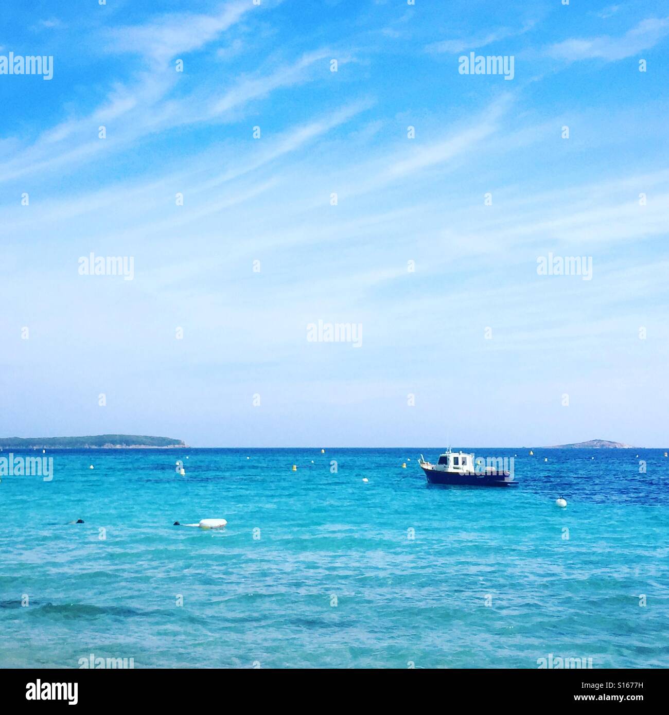 Boat floating in the bay on the clear blue sea Stock Photo