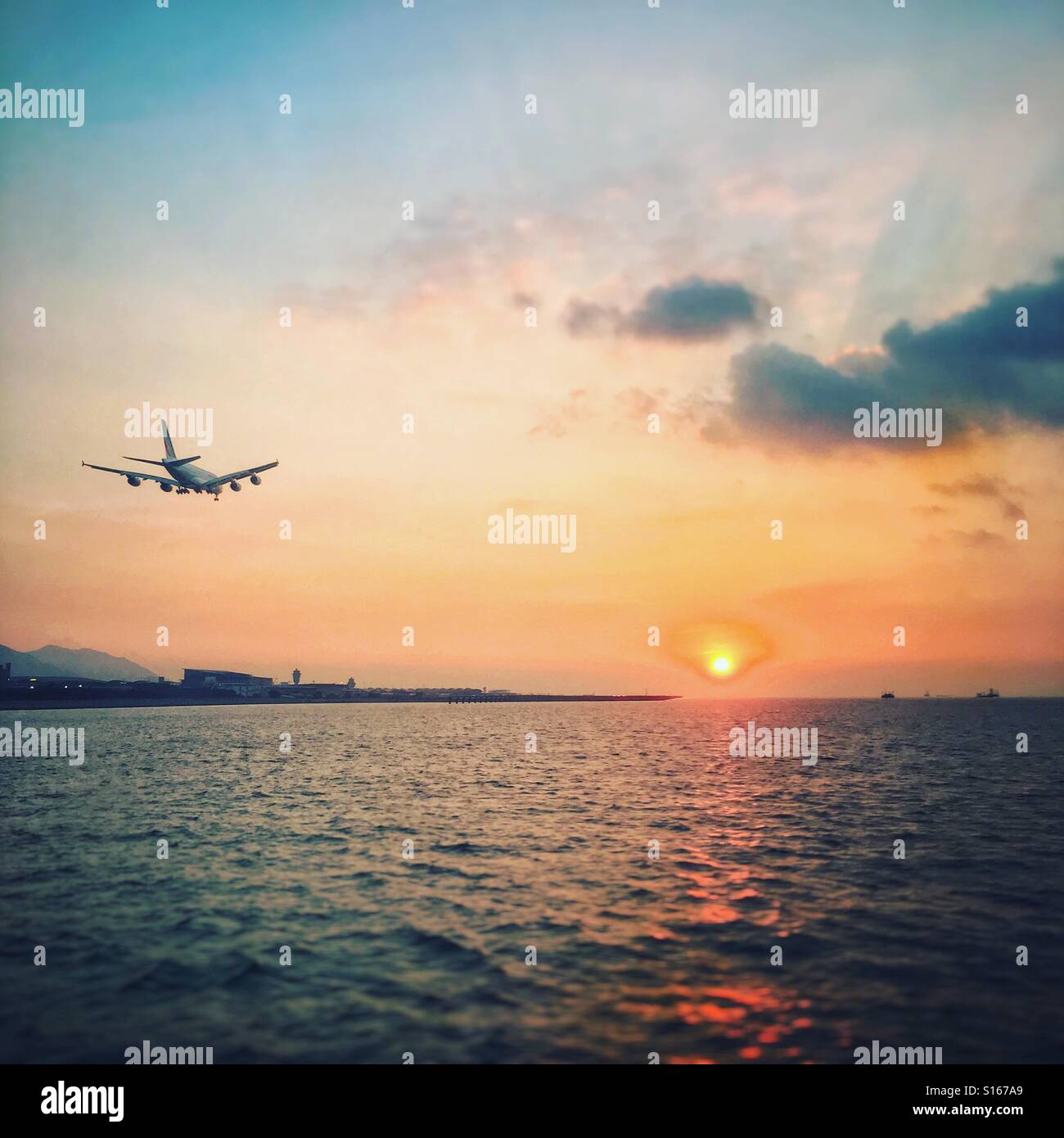 Plane landing into the sunset Stock Photo