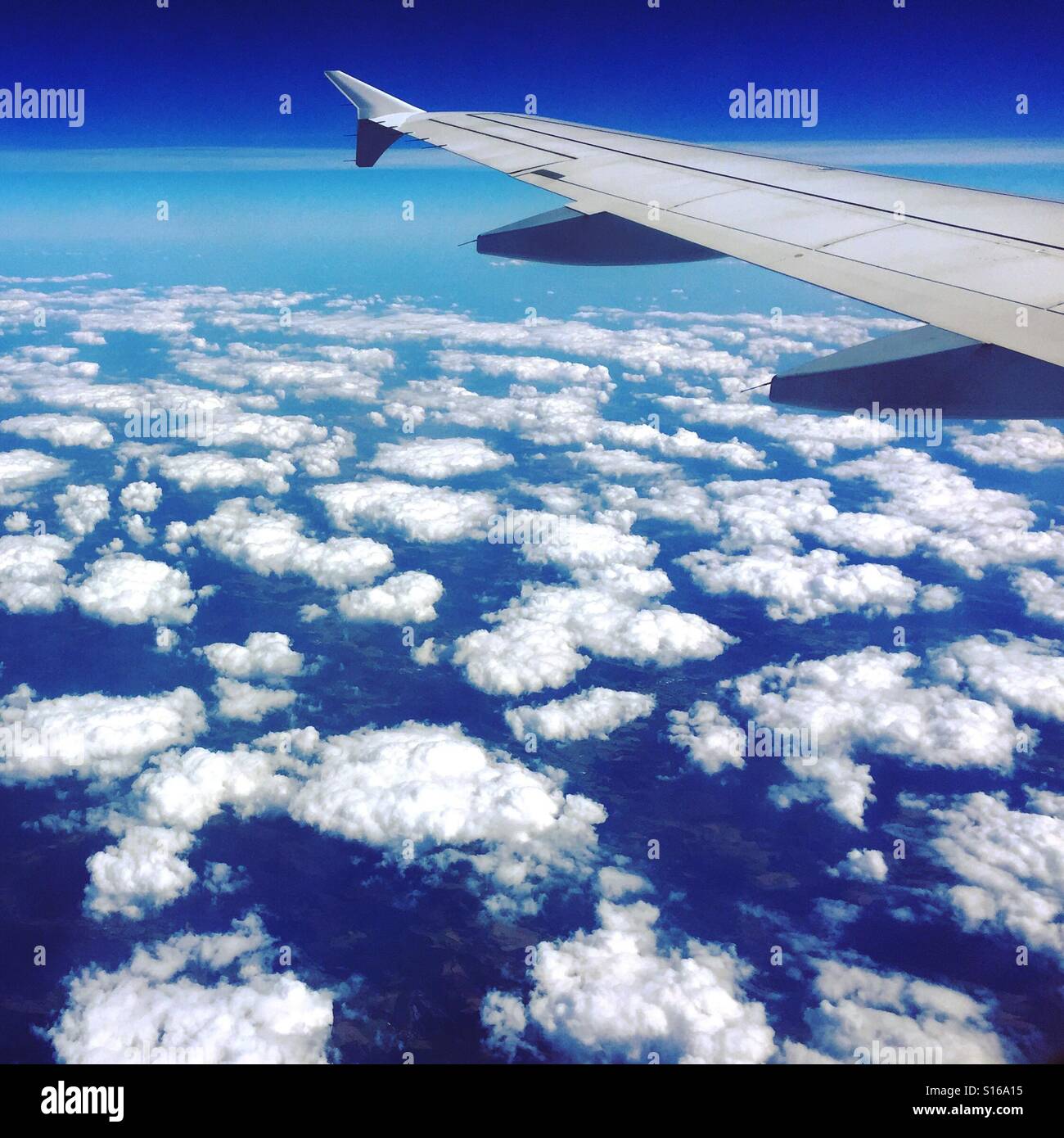 Flying high above the fluffy white clouds Stock Photo