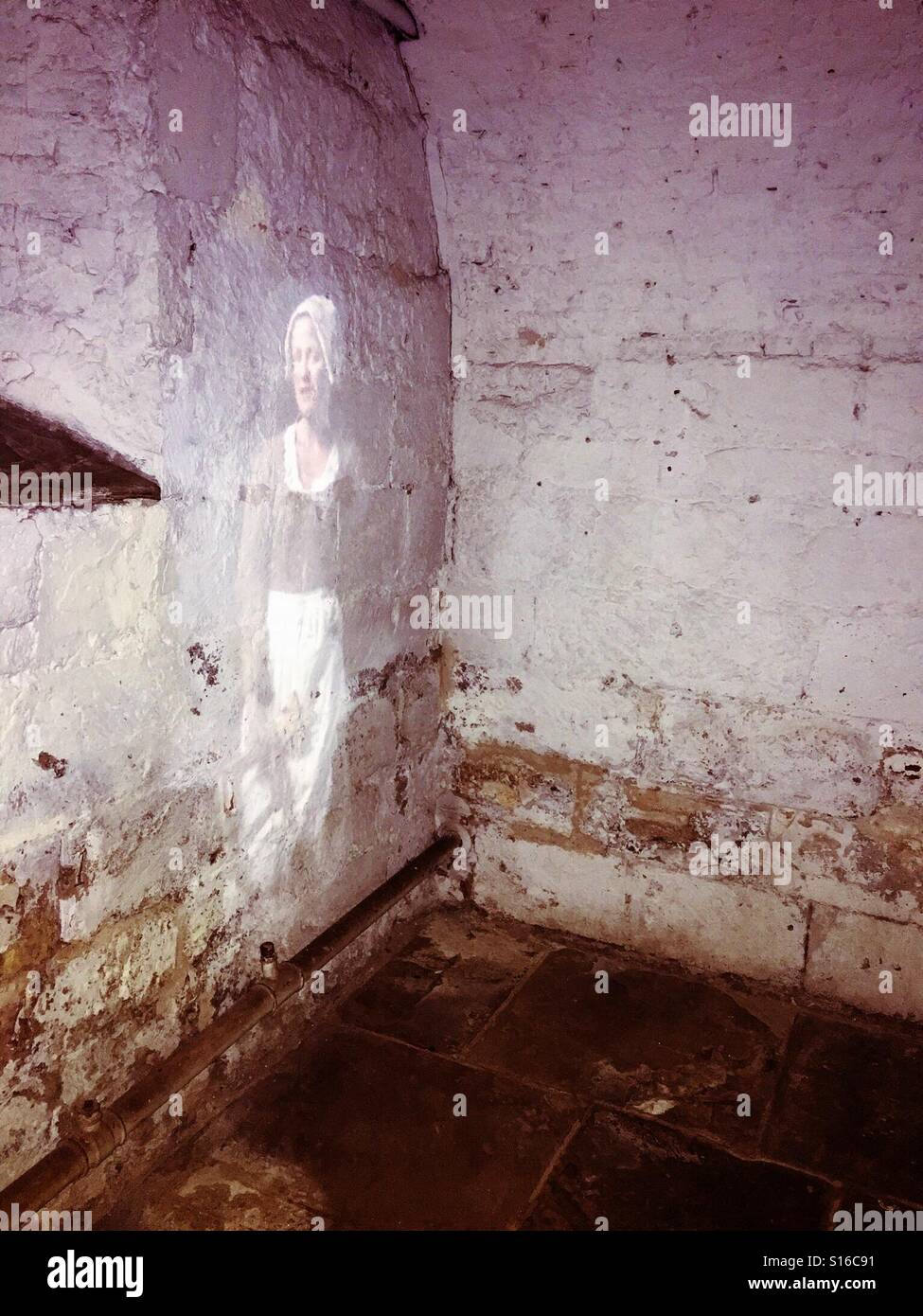 Projection of a woman on a former prison wall, looking like a ghost - Smartphone Captured Stock Image