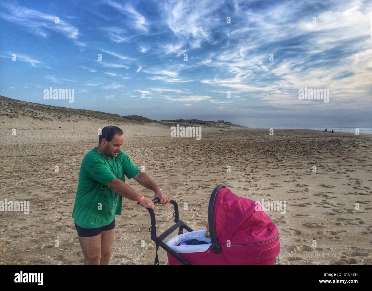 Man pushing a  baby stroller on the beach  Atlantic Ocean France - Smartphone Captured Stock Image