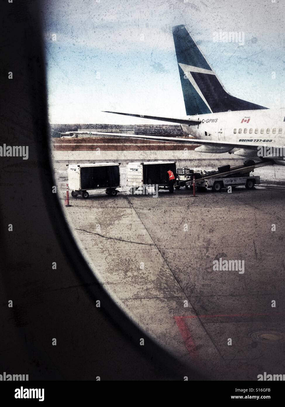 Luggage is loaded into a passenger aircraft. - Smartphone Captured Stock Image