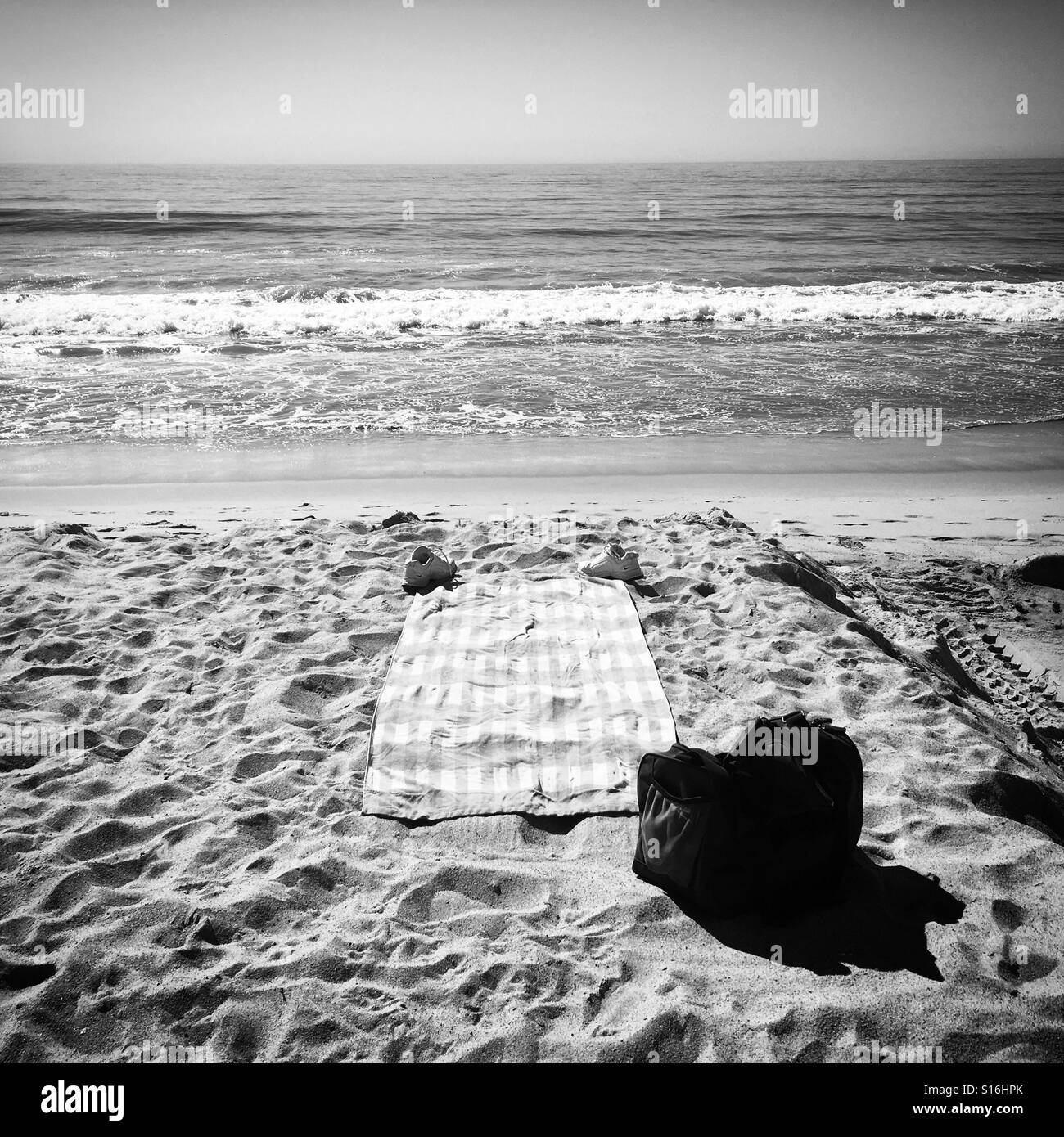 B&W beach scene with towel on sand Stock Photo